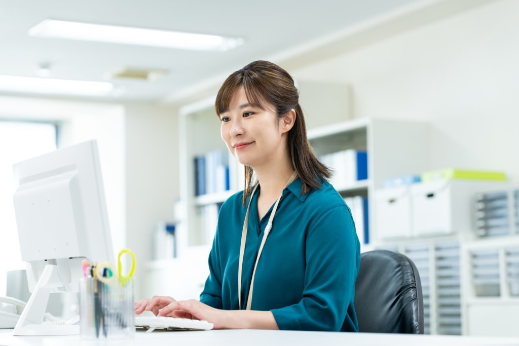オフィスデスクでパソコン操作をする女性会社員
