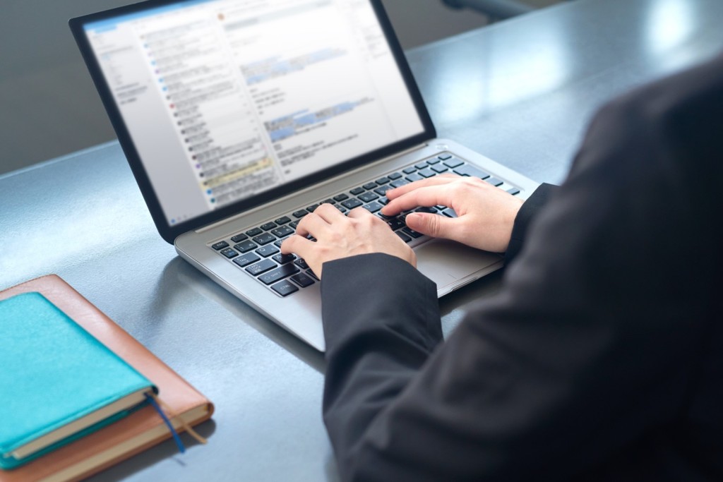 ノートPCで作業をする人の手元と手帳